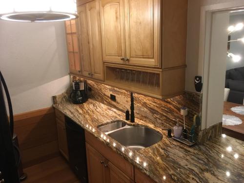 a kitchen with a sink and wooden cabinets at Beach Townhouse in St Thomas