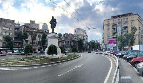 uma rua da cidade com uma estátua no meio de uma estrada em Central Old city 2 em Bucareste