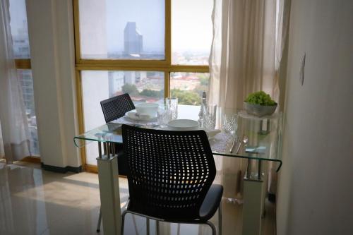 a glass table with two chairs and a window at Hotel Suites Bernini in Guadalajara