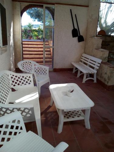 a group of white benches and tables on a patio at CASA DEGLI OLEANDRI in Carlentini