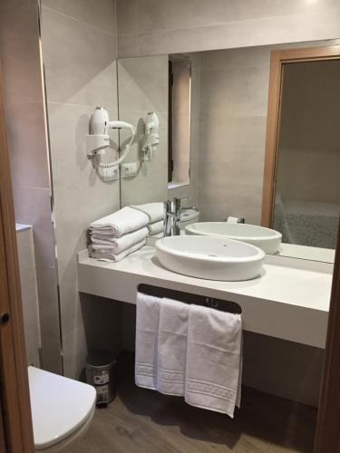 a bathroom with a sink and a toilet and a mirror at Hostal Infantes in Toledo