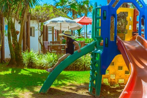a woman is climbing up a slide on a playground at Hotel VillaReal Guaratuba - Caieiras in Guaratuba