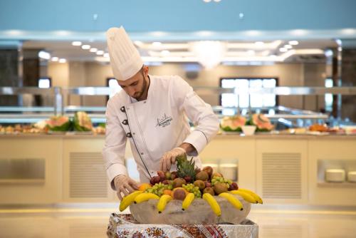 a chef preparing a pile of fruit on a table at Le Bosphorus Hotel - Waqf Safi in Al Madinah