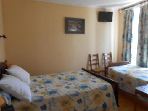 a bedroom with a bed and a table and chairs at La Vieille Auberge in Saint-Privat-dʼAllier
