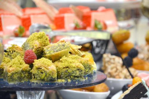 a plate of food with broccoli and berries on it at MADEN Hotel in Al Madinah