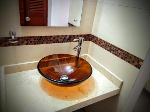 a sink in a bathroom with a wooden bowl at Hotel el Atajo in Yopal