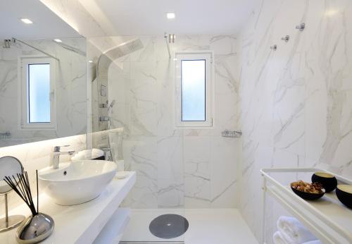 biała łazienka z umywalką i prysznicem w obiekcie Braganza apartment w Funchal