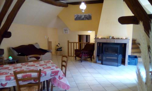 un salon avec une table et une cheminée dans l'établissement Gîte de la licorne, à Moissey