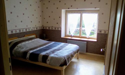 une chambre avec un lit et une fenêtre dans l'établissement Gîte de la licorne, à Moissey