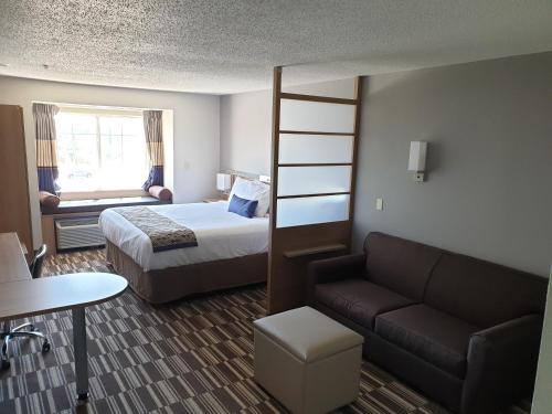 a hotel room with a bed and a couch at Microtel Inn & Suites by Wyndham Augusta/Riverwatch in Augusta