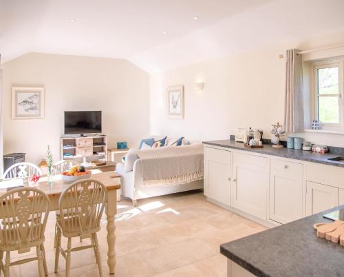 a kitchen and living room with a bed and a table at Hill Stables in Woodbridge