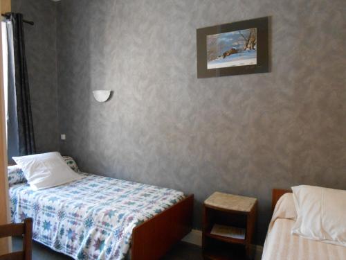a bedroom with two beds and a picture on the wall at La Vieille Auberge in Saint-Privat-dʼAllier