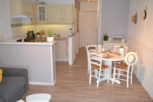 a kitchen and a living room with a table and chairs at L'instant Canal in Capestang