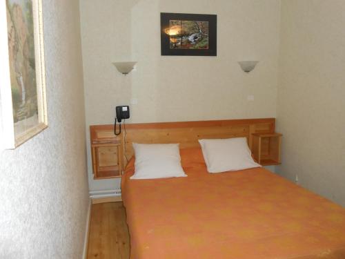a bedroom with a bed and a phone on the wall at La Vieille Auberge in Saint-Privat-dʼAllier