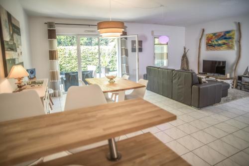 a living room with a table and a couch at Appartement 90 m2 avec parking terrasse balcons, proche du port et plages in Arcachon