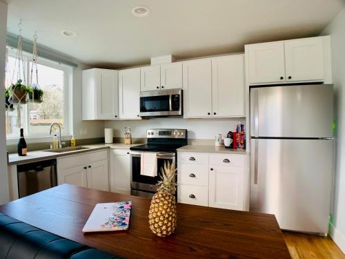 a kitchen with white cabinets and a table with a pineapple at Birdhouse on Green Lake in Seattle