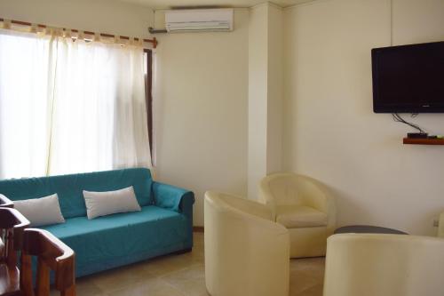 ein Wohnzimmer mit einem blauen Sofa und Stühlen in der Unterkunft Apartments Center GSV in Puerto Villamil