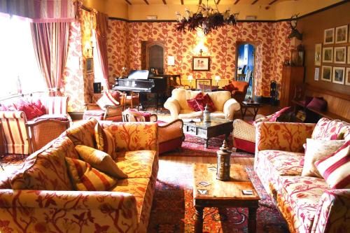 uma sala de estar com sofás e um piano em Augill Castle em Kirkby Stephen