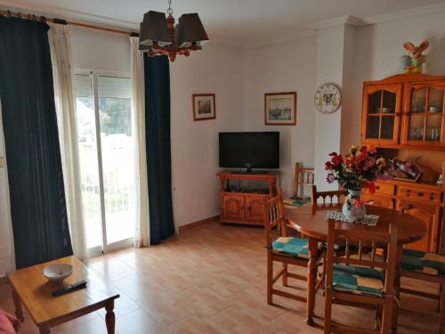 a living room with a table and a television at Hotel Paloma in San Pedro del Pinatar