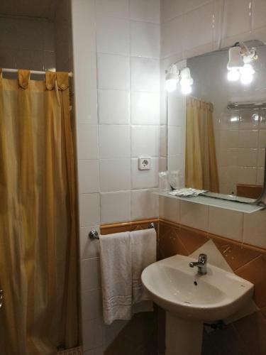 a bathroom with a sink and a shower with a mirror at Hotel Paloma in San Pedro del Pinatar