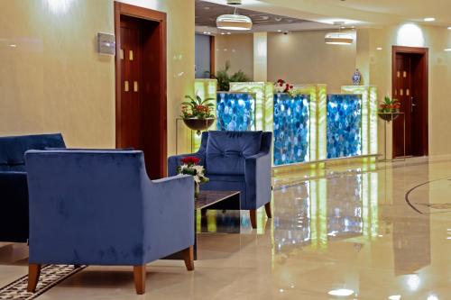 a lobby with blue chairs and a table at Le Bosphorus Hotel - Waqf Safi in Al Madinah