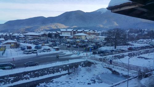 a town in the snow with cars parked at Koko's apartments in Bansko