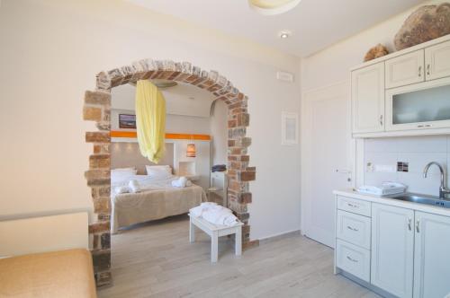 a kitchen and living room with a bed in the background at Villa Adriana Hotel in Agios Prokopios