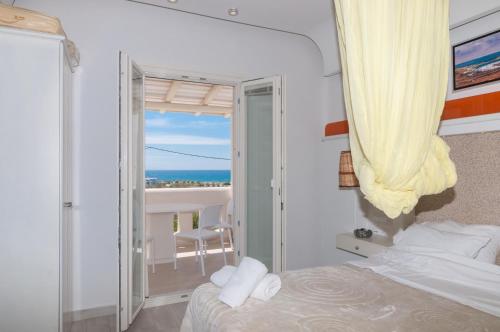 a bedroom with a bed and a view of the ocean at Villa Adriana Hotel in Agios Prokopios