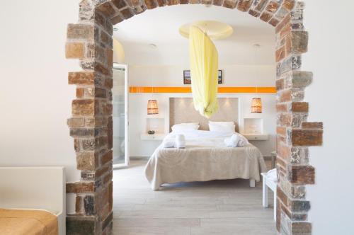 a bedroom with a bed and an archway at Villa Adriana Hotel in Agios Prokopios