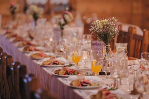 a long table with plates of food and wine glasses at Hotel Strachanovka - Jánska Koliba in Liptovský Ján