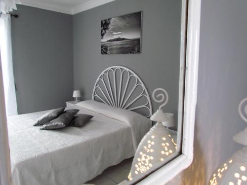 a bedroom with a white bed and a mirror at B&B Il Cappero in Lipari