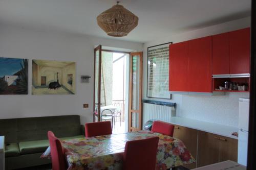 una cucina con tavolo e armadietti rossi di CELTIC ALCOVE & small art exhibition a Esino Lario