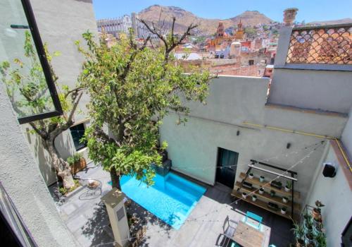 an overhead view of a building with a tree and a swimming pool at Antigua Trece Hotel Fusión in Guanajuato