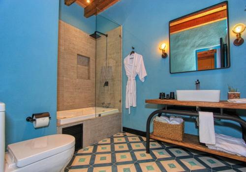 a bathroom with a toilet and a sink and a tub at Antigua Trece Hotel Fusión in Guanajuato