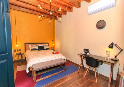 a bedroom with a bed and a desk and a desk at Antigua Trece Hotel Fusión in Guanajuato