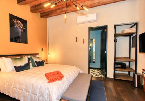 a bedroom with a large white bed and a mirror at Antigua Trece Hotel Fusión in Guanajuato