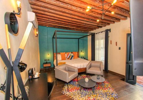 a bedroom with a bed and a tv in a room at Antigua Trece Hotel Fusión in Guanajuato