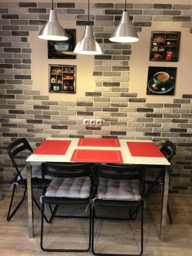 a red and white table and chairs in front of a brick wall at VIP Apartment on Khrutskogo in Polatsk