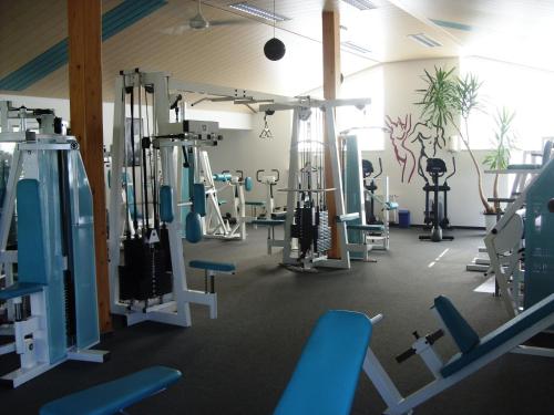a gym with a lot of treadmills and machines at Pension Fitnessoase in Eußenheim