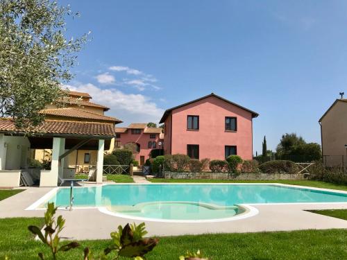 a villa with a swimming pool in front of a house at Borgo Venecca in Fonteblanda