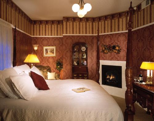 a bedroom with a bed and a fireplace at Churchill Manor in Napa