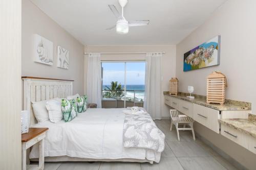Schlafzimmer mit einem Bett und Meerblick in der Unterkunft Sands Beach Breaks Luxury Beach Front Ballito in Ballito
