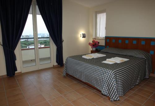 a hotel room with a bed and a window at Hotel Resort Il Panfilo in Lago Patria