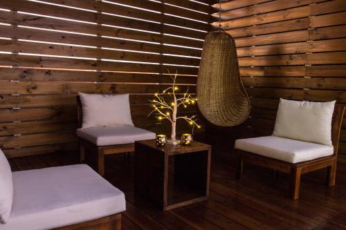 a room with two chairs and a table with a lamp at Hotel Avenida en Arica in Arica