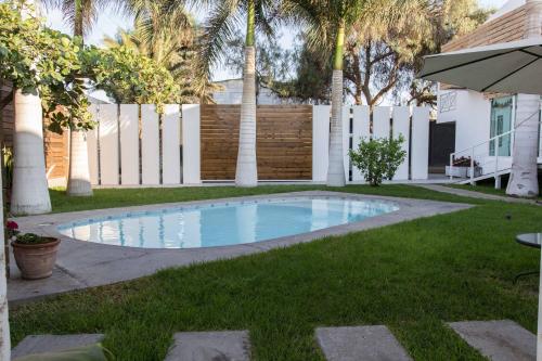 a swimming pool in a yard with palm trees at Hotel Avenida en Arica in Arica