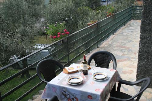 a table with two chairs and a bottle of wine at La terrazza sugli ulivi in Toscolano Maderno