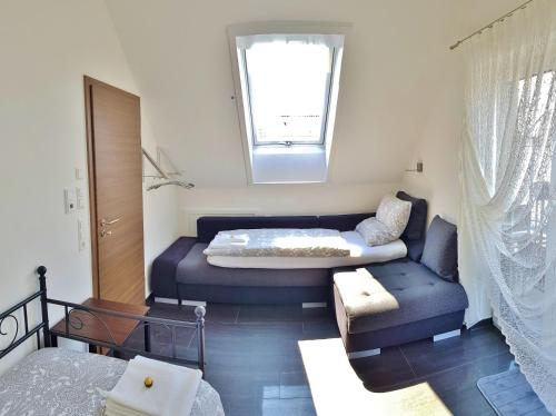 a bedroom with a bed and a couch and a window at Casa Muro in Friedrichshafen