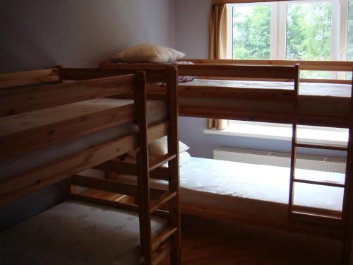 two bunk beds in a room with a window at Guest House Kalnu pūpoli in Šengeida
