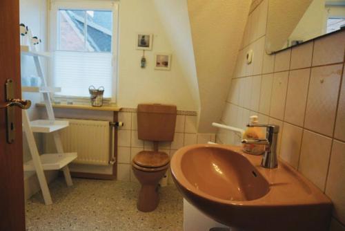 a bathroom with a sink and a toilet at Tolle Ferienwohnung in schönem Bauernhaus in Fehmarn