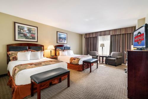 una camera d'albergo con due letti e una televisione di Winnemucca Inn & Casino a Winnemucca